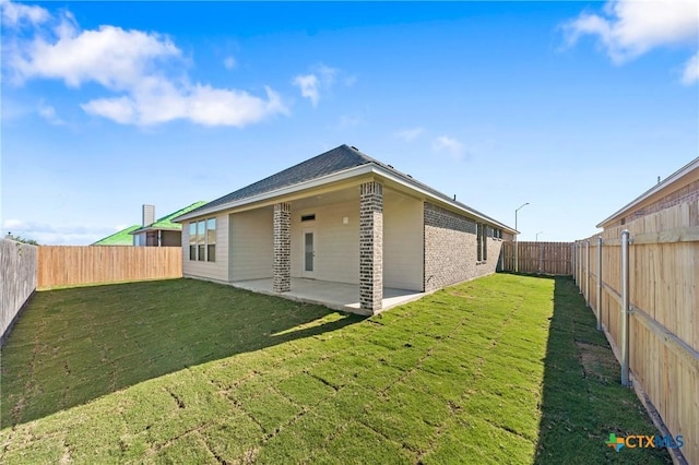 back of house with a lawn and a patio area