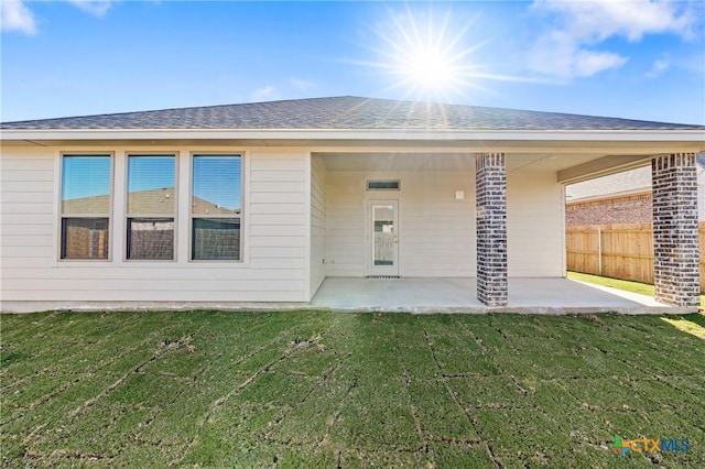 back of property with a patio and a lawn