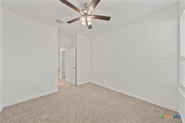 spare room with ceiling fan and light colored carpet