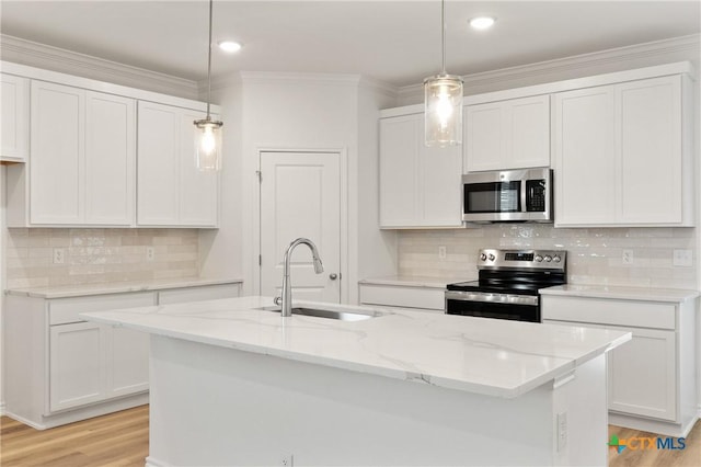 kitchen with a kitchen island with sink, sink, hanging light fixtures, white cabinetry, and stainless steel appliances