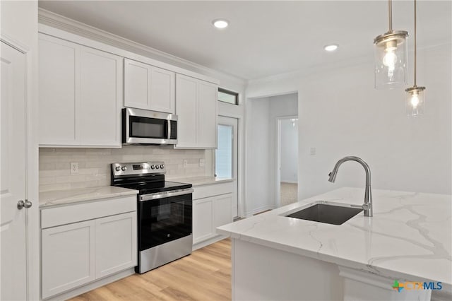 kitchen featuring white cabinets, sink, hanging light fixtures, light stone countertops, and appliances with stainless steel finishes