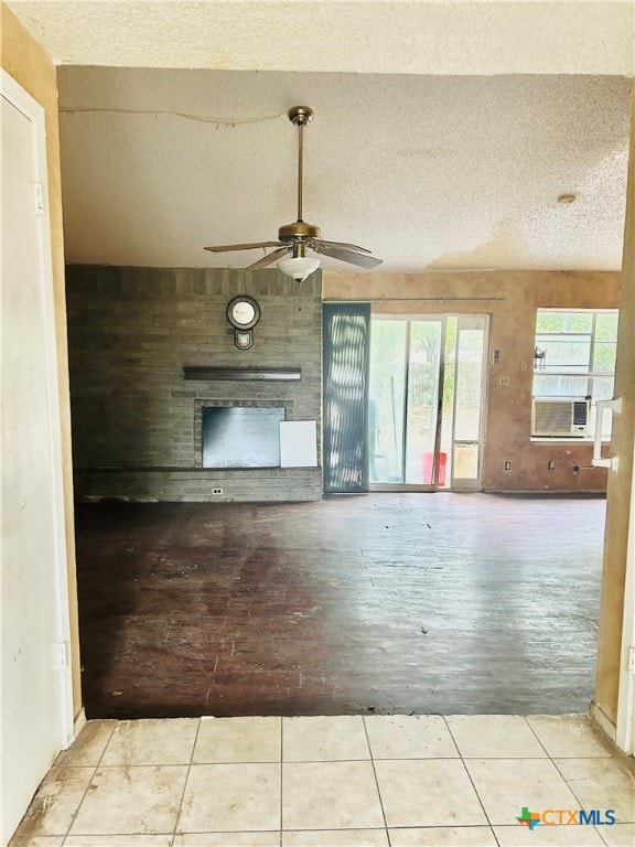 unfurnished living room with light tile patterned flooring, ceiling fan, a textured ceiling, and cooling unit