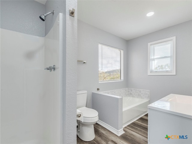 bathroom featuring a bath, hardwood / wood-style floors, toilet, and a healthy amount of sunlight