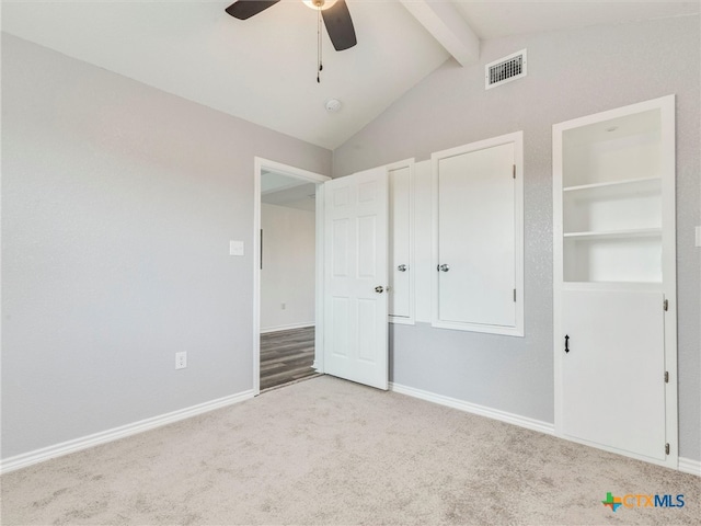 unfurnished bedroom with ceiling fan, lofted ceiling with beams, and light carpet