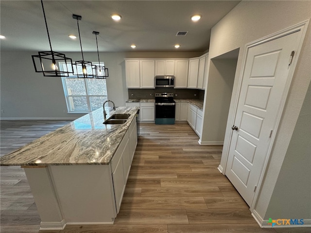 kitchen featuring sink, white cabinetry, hardwood / wood-style floors, and stainless steel appliances