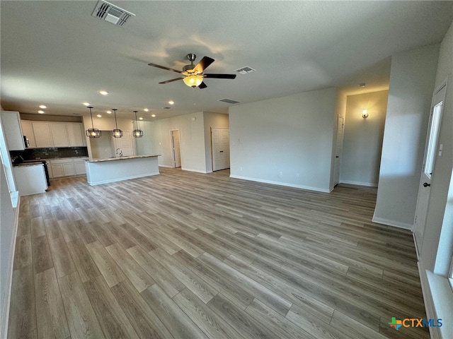 unfurnished living room with ceiling fan and light hardwood / wood-style flooring