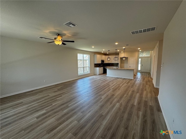 unfurnished living room with dark hardwood / wood-style flooring, a textured ceiling, and ceiling fan