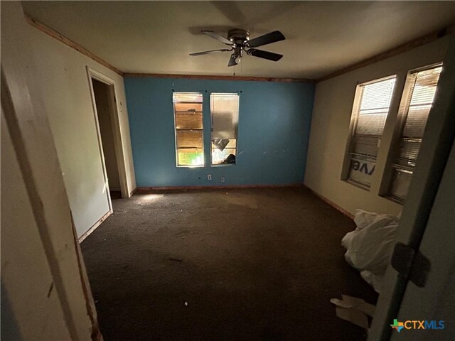 spare room featuring ornamental molding, baseboards, carpet, and ceiling fan
