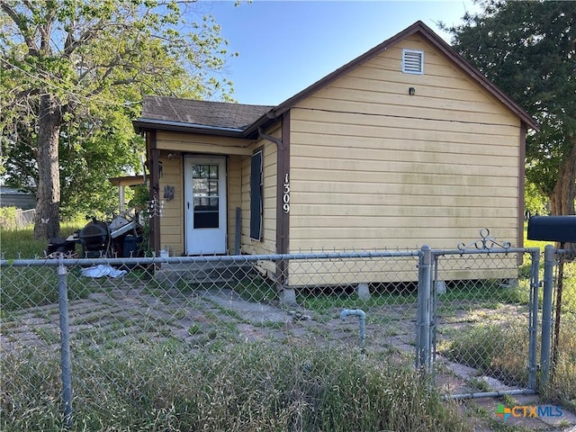 exterior space featuring roof with shingles and fence