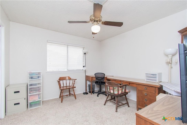 office space featuring light carpet, ceiling fan, and a textured ceiling