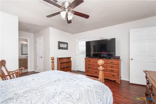 bedroom featuring baseboards, dark wood finished floors, a ceiling fan, ensuite bathroom, and a textured ceiling