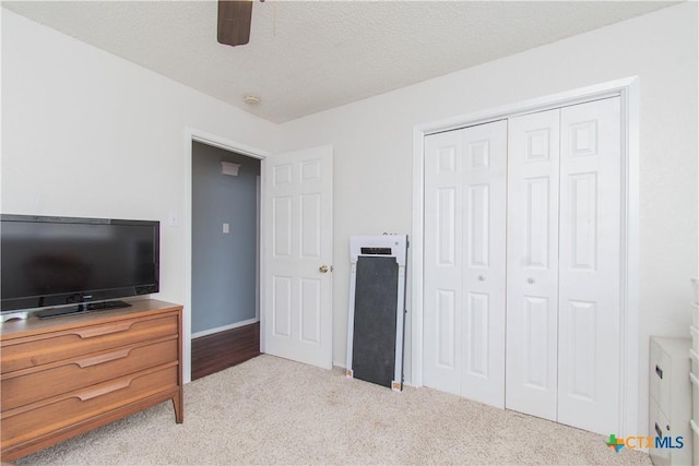 bedroom with a textured ceiling, a ceiling fan, baseboards, a closet, and carpet