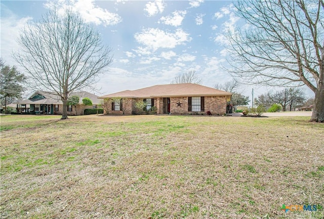 ranch-style home featuring brick siding and a front lawn