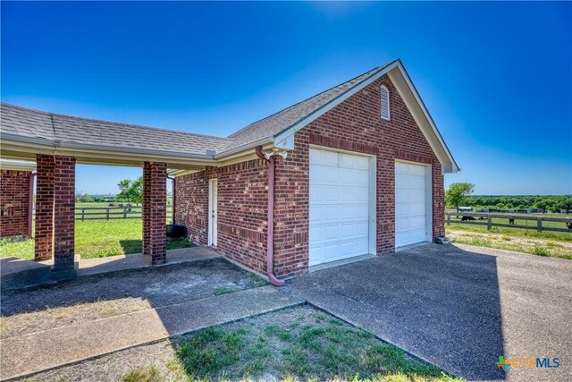 1041 Clarence Rd, Temple, TX 76501 - exterior space with brick siding, fence, a detached garage, and a shingled roof