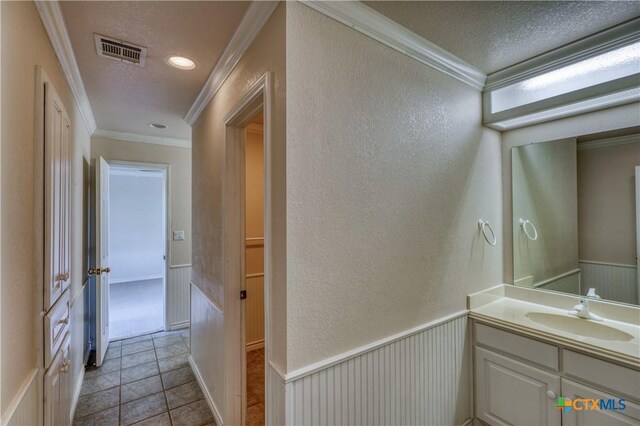 1041 Clarence Rd, Temple, TX 76501 - bathroom with a textured wall, visible vents, vanity, and ornamental molding