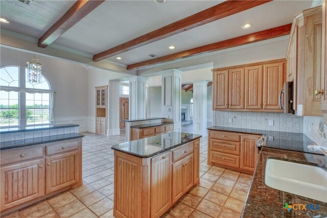 1041 Clarence Rd, Temple, TX 76501 - kitchen with beam ceiling, a healthy amount of sunlight, a sink, and a kitchen island