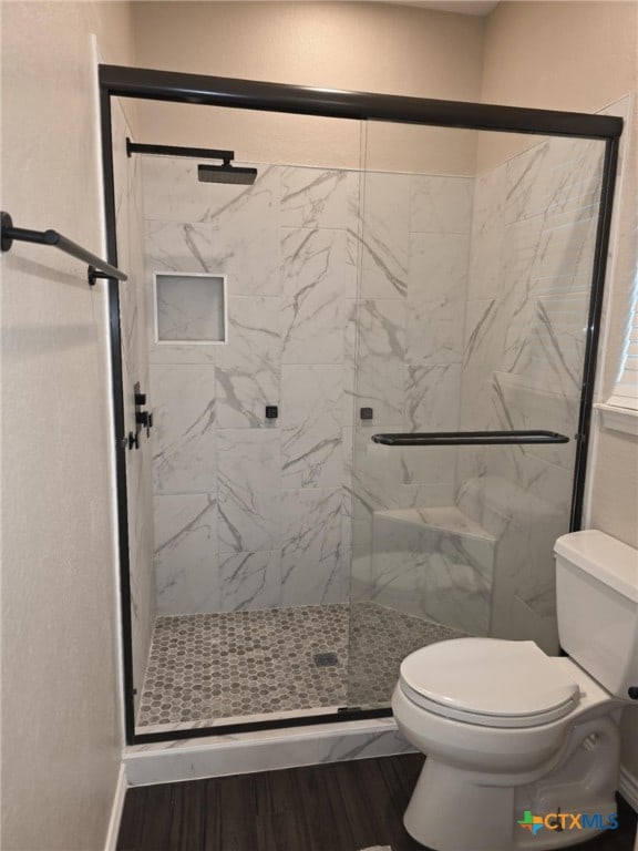 102 Lexington Ln, Victoria, TX 77901 - full bathroom featuring toilet, a marble finish shower, and wood finished floors