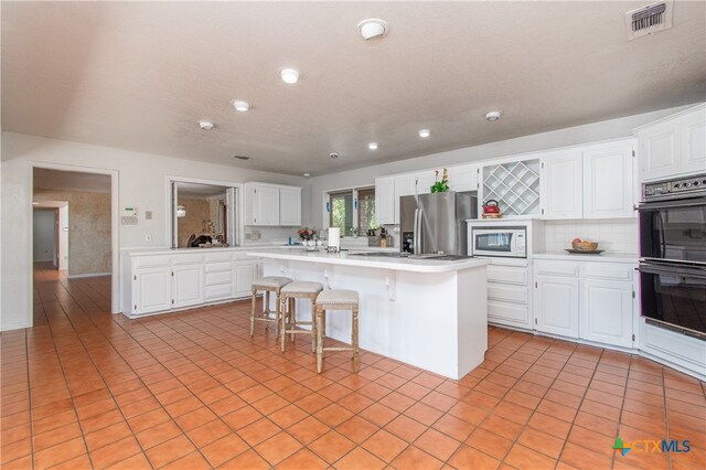 kitchen with white cabinets, a center island, and a breakfast bar