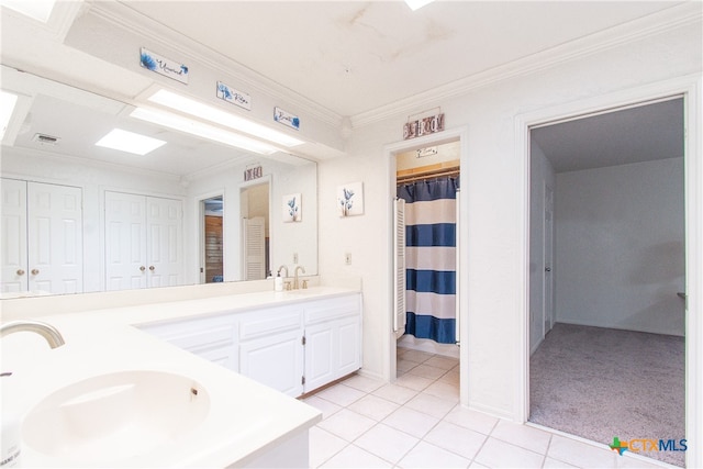 bathroom featuring tile patterned flooring, vanity, and crown molding