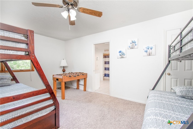 bedroom with a textured ceiling, light carpet, and ceiling fan