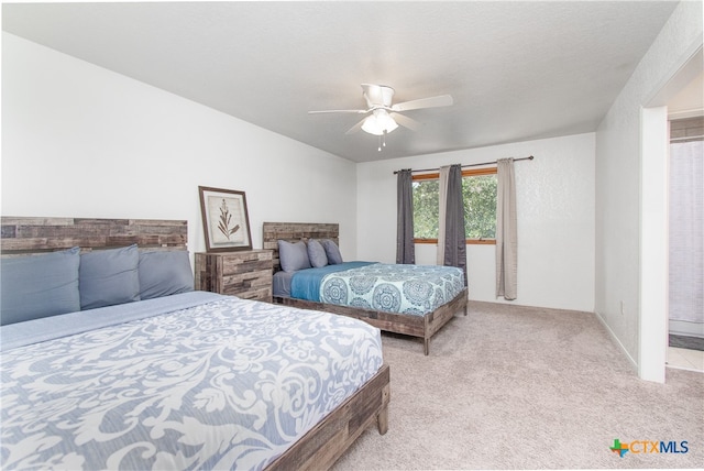 bedroom with a textured ceiling, light carpet, and ceiling fan