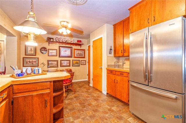 808 E Randall St, Beeville, TX 78102 - kitchen with stainless steel fridge, light countertops, ceiling fan, brown cabinetry, and open shelves