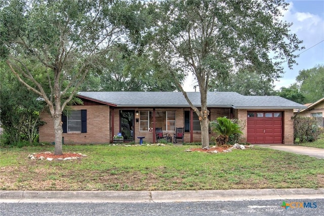 808 E Randall St, Beeville, TX 78102 - ranch-style home with covered porch, a garage, a front lawn, brick siding, and concrete driveway