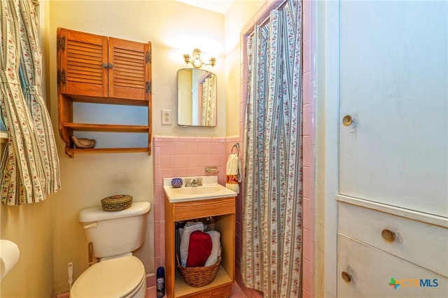 808 E Randall St, Beeville, TX 78102 - full bath with tile walls, a wainscoted wall, a shower with curtain, and vanity