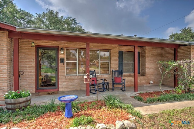808 E Randall St, Beeville, TX 78102 - rear view of property featuring a porch and brick siding