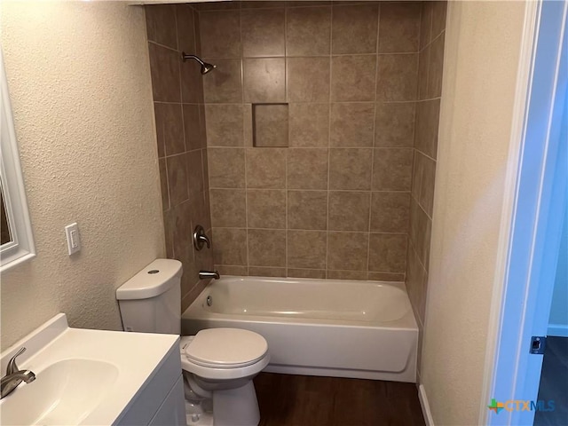 full bath featuring a textured wall, shower / tub combination, toilet, wood finished floors, and vanity