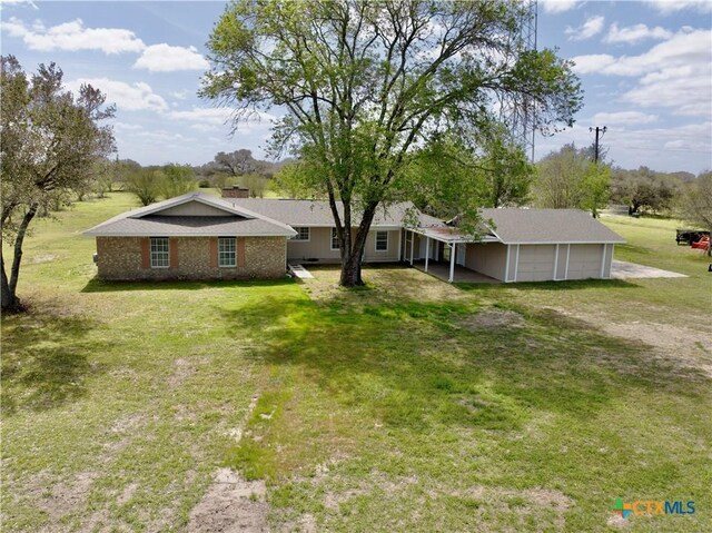 view of yard featuring an attached garage and driveway