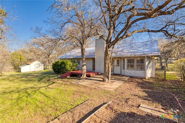 back of property with a yard, a patio, a storage unit, and a deck