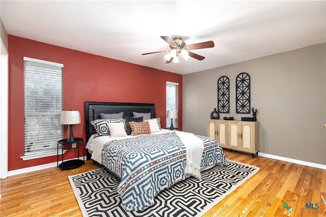 bedroom featuring multiple windows, light wood-type flooring, and ceiling fan