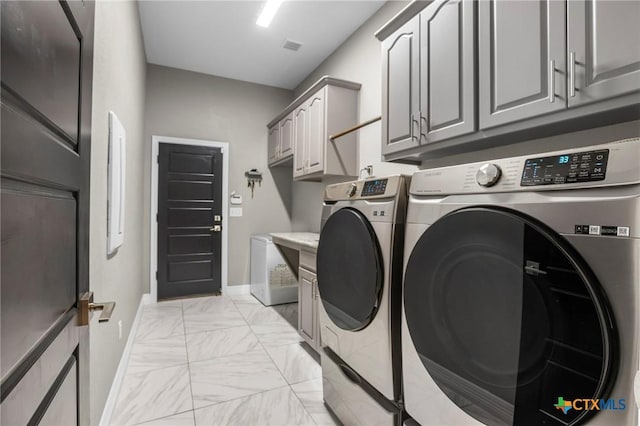 laundry area with baseboards, cabinet space, separate washer and dryer, and marble finish floor