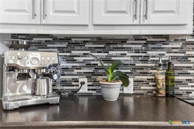 details featuring white cabinetry, dark countertops, and backsplash