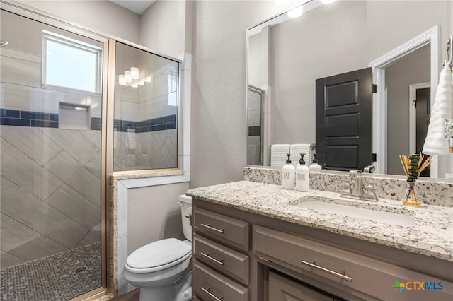 bathroom with vanity, toilet, and a stall shower