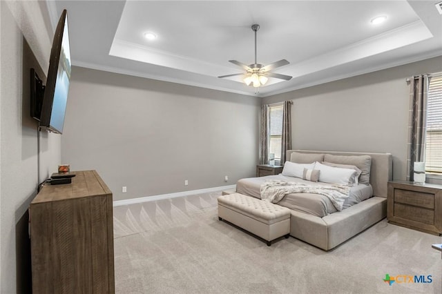 bedroom with ornamental molding, multiple windows, light carpet, and a tray ceiling