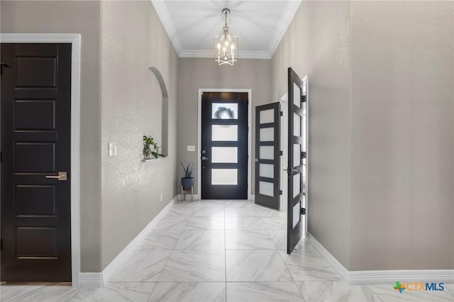 foyer featuring crown molding, marble finish floor, a chandelier, and baseboards