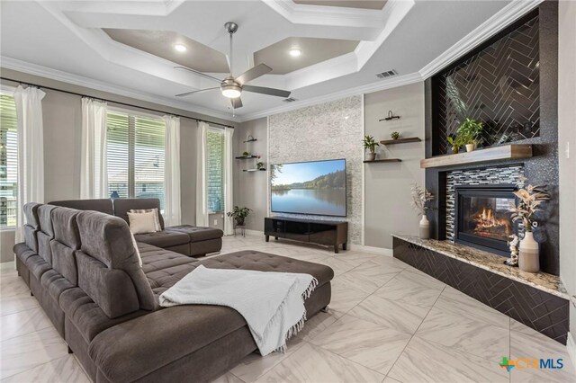 living area with visible vents, a healthy amount of sunlight, a ceiling fan, and ornamental molding