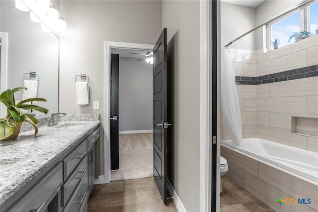 full bathroom featuring ceiling fan, toilet, vanity, baseboards, and shower / tub combo