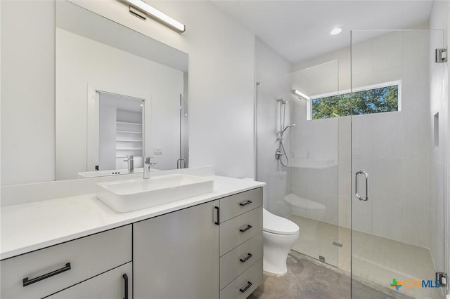 bathroom featuring vanity, toilet, and a shower with shower door