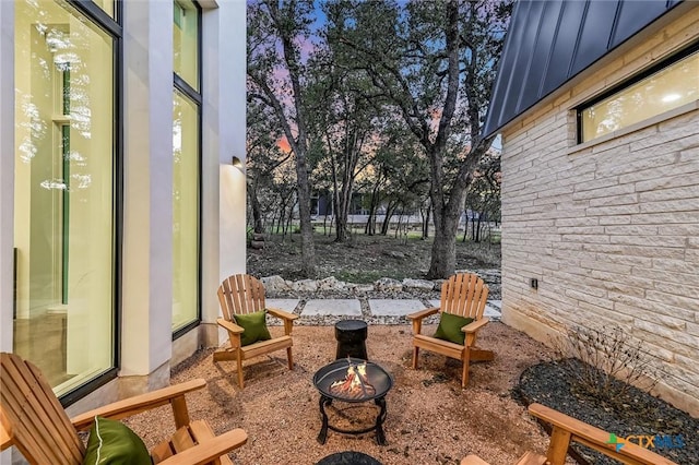 patio terrace at dusk featuring a fire pit