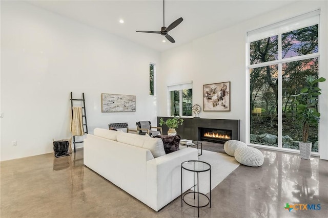 living room with a towering ceiling and ceiling fan