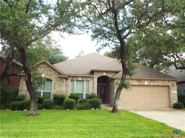 3241 Ranch Park Trl, Round Rock, TX 78681 - view of front of home featuring roof with shingles, an attached garage, concrete driveway, a front lawn, and a chimney