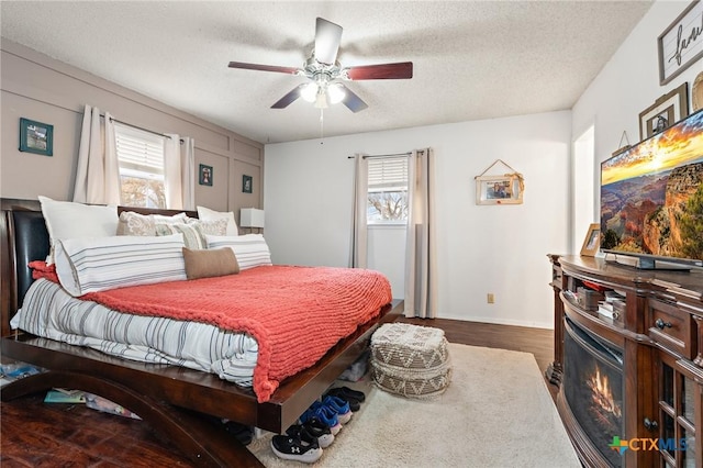 109 E Moonlight Dr, Robinson, TX 76706 - bedroom with ceiling fan, dark hardwood / wood-style floors, a textured ceiling, and multiple windows