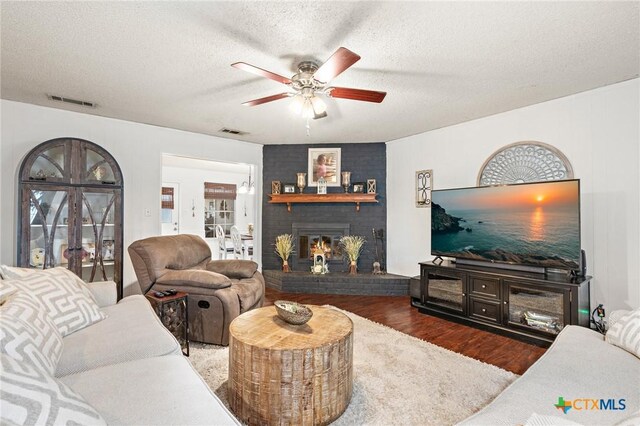 109 E Moonlight Dr, Robinson, TX 76706 - living room with ceiling fan, a brick fireplace, dark hardwood / wood-style flooring, and a textured ceiling
