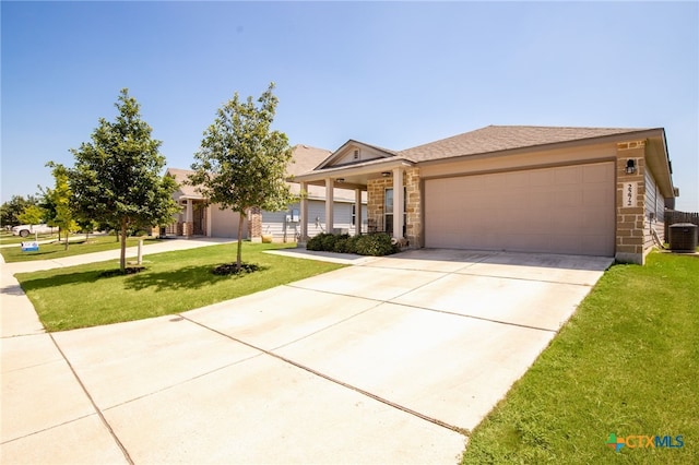 view of front of house featuring central air condition unit, a garage, and a front yard