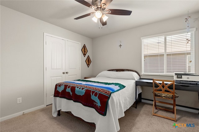 bedroom with ceiling fan, light carpet, and a closet