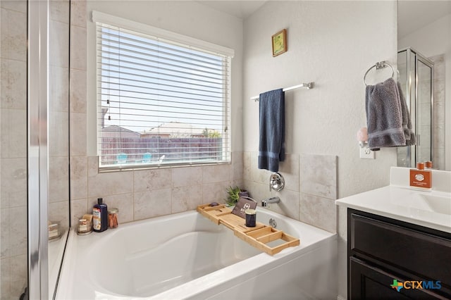 bathroom with plus walk in shower, vanity, and a healthy amount of sunlight