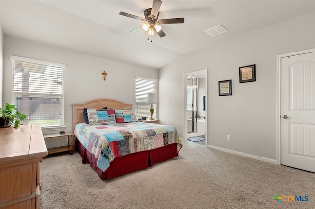 bedroom featuring ensuite bathroom, light colored carpet, lofted ceiling, and multiple windows